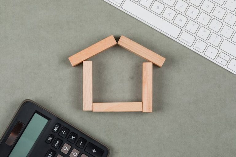casa de madera junto a calculadora y teclado