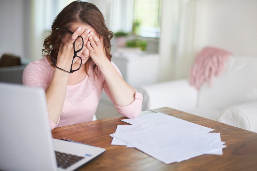 Mujer preocupada revisando documentos de una vivienda con posibles cargas