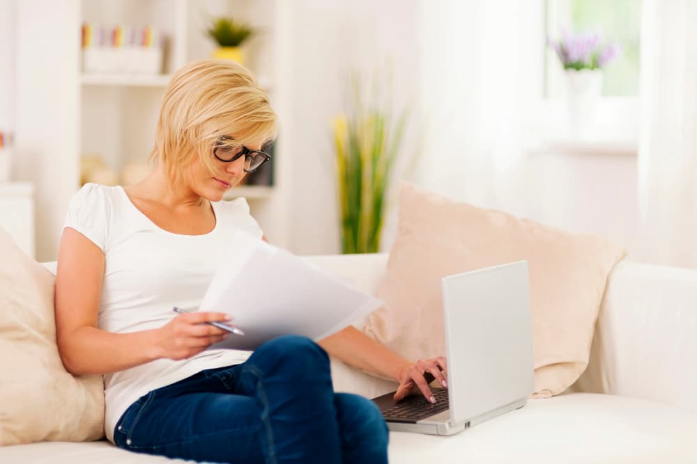 Mujer consultando online cómo saber si un piso tiene cargas