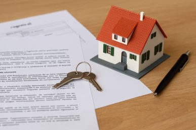 Modelo de casa con llaves y documentos de propiedad